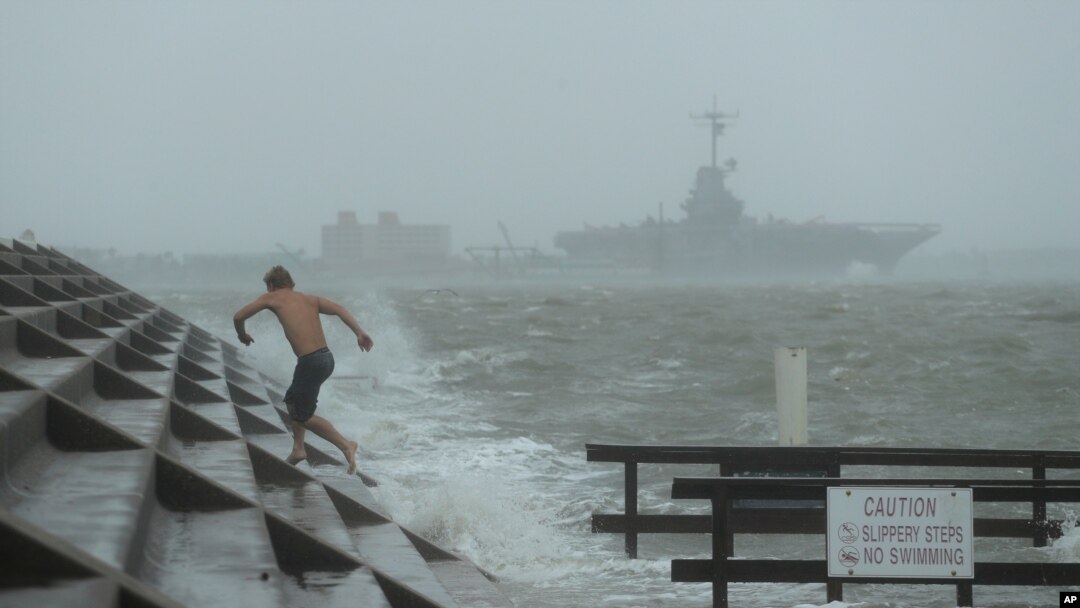 A man jumps from a wave as Hurricane Hanna begins to make landfall, July 25, 2020, in Corpus Christi, Texas. 
