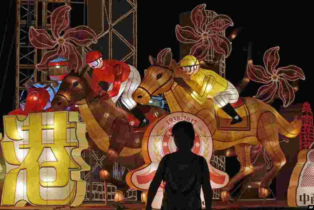 A woman stand in front of the lanterns decorations which are displayed to mark the 20th anniversary of Hong Kong's handover to Chinese rule, in Hong Kong.