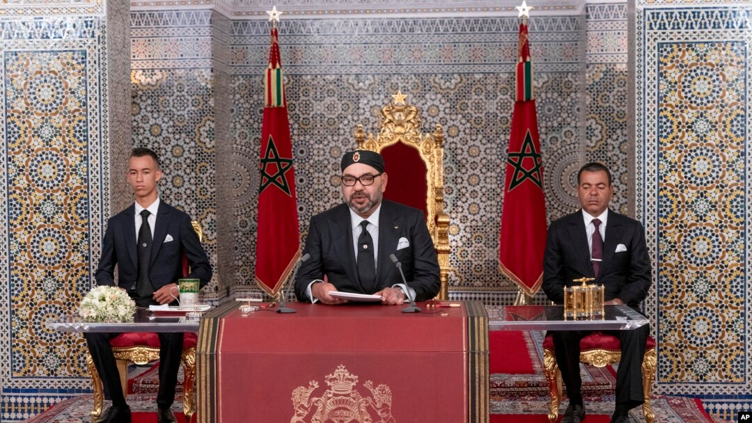 In this photo provided by the Moroccan News Agency (MAP), Morocco's King Mohammed VI, center, accompanied by his son Crown Prince Moulay Hassan, left, and brother Prince Moulay Rashid addresses the Nation in a speech aired on TV, at the Royal Palace.
