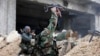 Syrian soldiers fire their weapons during a battle with rebel fighters at the Ramouseh front line, east of Aleppo, Syria, Dec. 5, 2016.