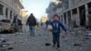FILE - A Syrian boy runs while carrying bread following a reported airstrike by government forces, in the Syrian town of Binnish, on the outskirts of Idlib.