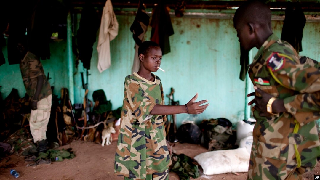 FILE - A May 2012 photo shows a young South Sudanese soldier who appeared to be drunk reaching for a lighter for his cigarette at the Sudan People's Liberation Army (SPLA) headquarters in Bentiu, Unity State.