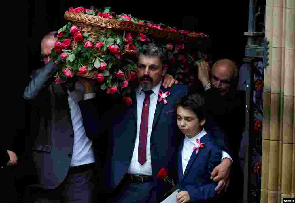 Andrew Roussos puts a hand around his son Xander as he carries his daughter Saffie Rose Roussos' coffin, the youngest victim of the bombing of the Manchester Arena, at her funeral at Manchester Cathedral, Britain.