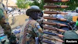 FILE - A South Sudanese army soldier stands next to a machine gun mounted on a truck in Malakal town, some 500 km (312 miles) northeast of the capital, Juba.