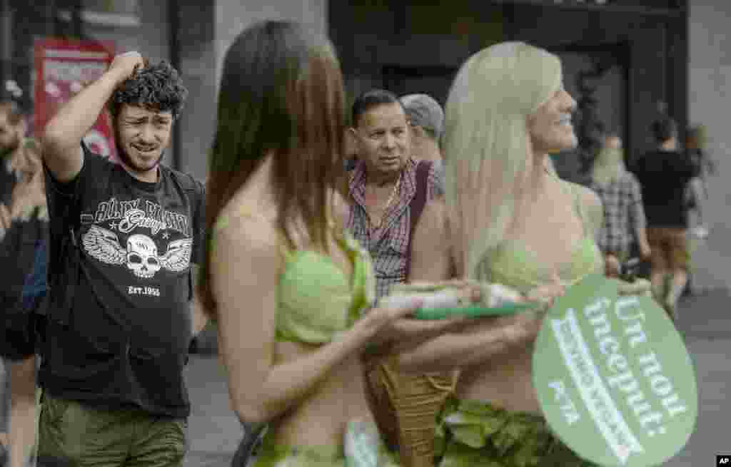 A man grimaces walking by the &quot;Lettuce Ladies&quot;, a group of PETA activists, during an event promoting a vegan lifestyle, downtown Bucharest, Romania.