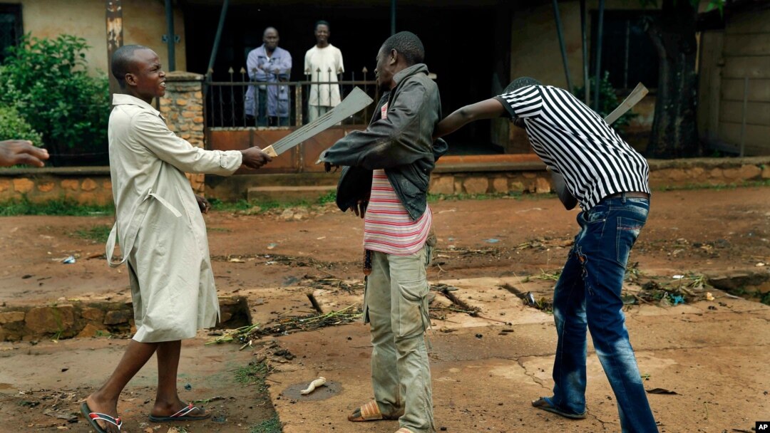 FILE - Muslim men organized in militias with machetes rough up a Christian man while checking him for weapons in the Miskine neighbourhood of Bangui, Central African Republic, Dec. 13, 2013.