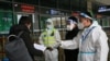 12月23日，警察和防疫人员在西安火车站检查旅客的文件。