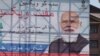 An Indian paramilitary soldier patrols past a hoarding of Indian Prime Minister Narendra Modi in Srinagar, Indian controlled Kashmir, June 24, 2021.