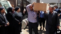 Egyptians remove a body for burial from the Zenhoum morgue in Cairo, August 19, 2013. 