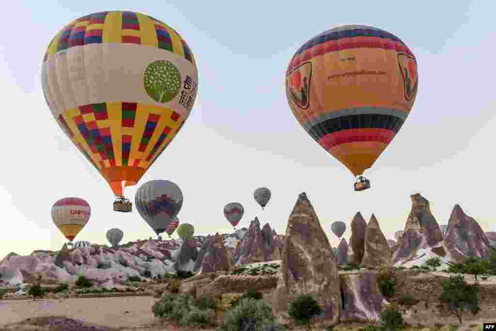 Hot air balloons glide during a flight over Nevsehir in Turkey's historical Cappadocia region, Central Anatolia, eastern Turkey.
