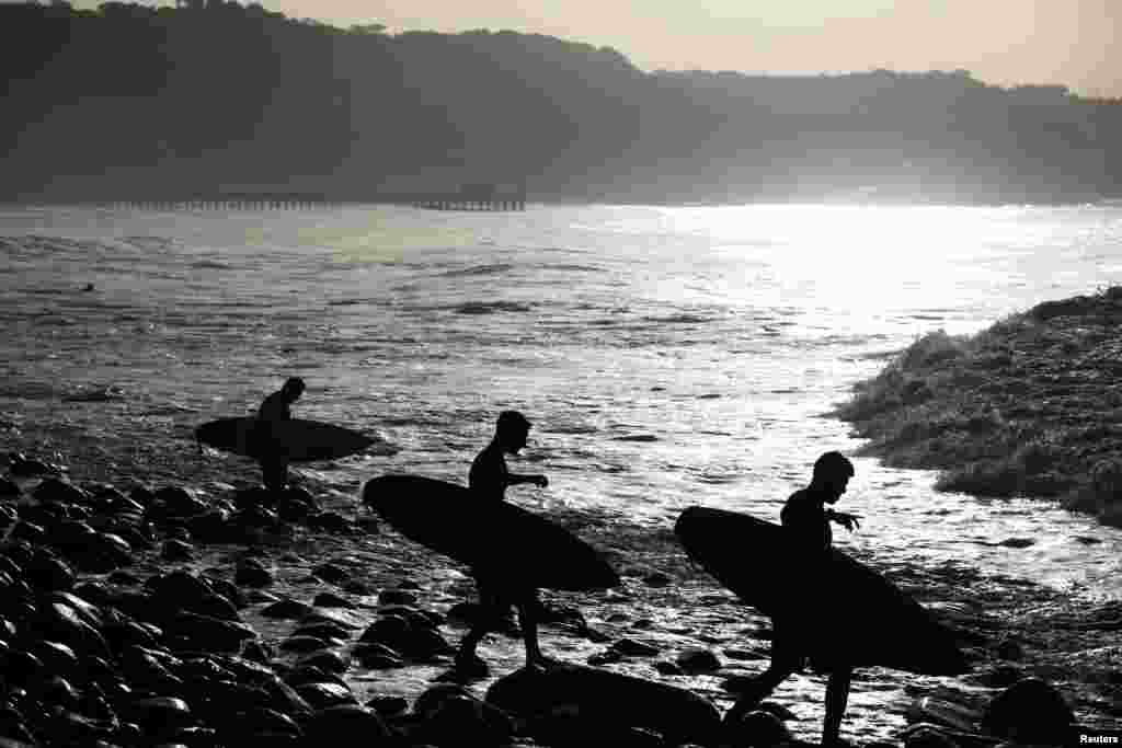 Surfers prepare to get in the water at Punta Roca Beach in La Libertad, El Salvador.