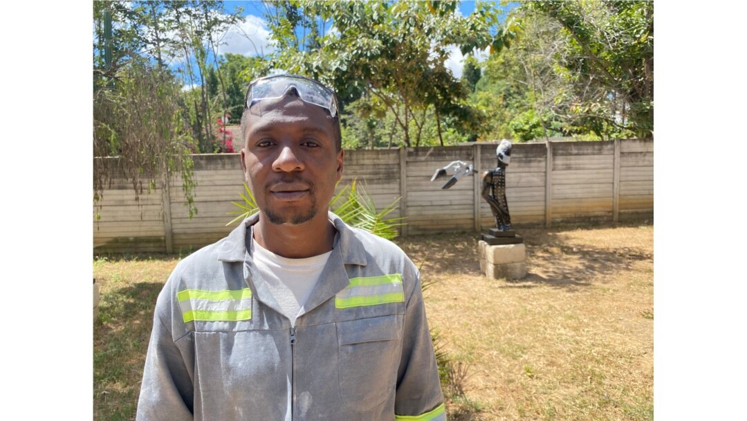Forty-year-old Zimbabwean sculptor David Ngwerume in front of his exhibit, called “Arms,” in what he calls a “COVID-19 Gallery” in Harare, April 23, 2021. (VOA/Columbus Mavhunga)