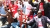 Protesters holding red crosses symbolizing victims of terror attacks are seen gathered outside the President's Office in Nairobi, Kenya, Nov. 25, 2014. (Mohammed Yusuf/VOA)