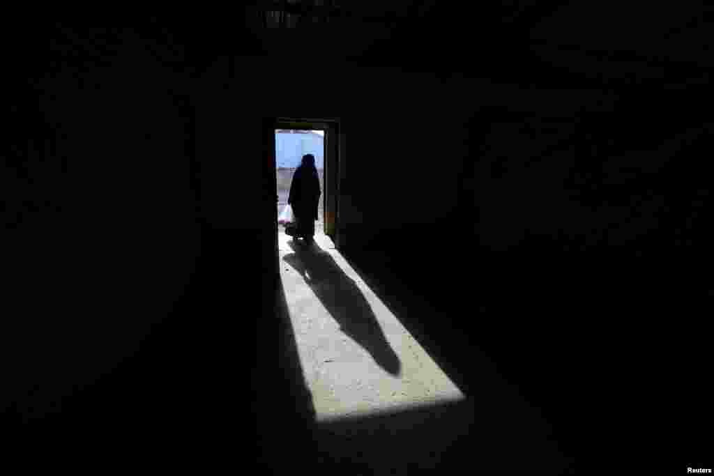 The shadow of a displaced old woman is seen in Hassan Sham camp, east of Mosul, Iraq.