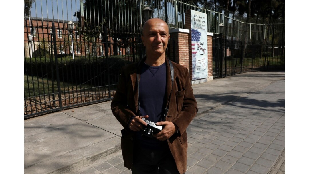 FILE - Veteran Iranian freelance photojournalist Kaveh Kazemi, who covered events following the U.S. embassy takeover in 1979, speaks with The Associated Press in front of the former embassy, in Tehran, Iran, Oct. 15, 2019.