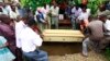 FILE - Pallbearers bury a coffin containing the remains of Francis Kamande, who was killed when unidentified gunmen attacked the coastal Kenyan town of Mpeketoni, June 18, 2014. 