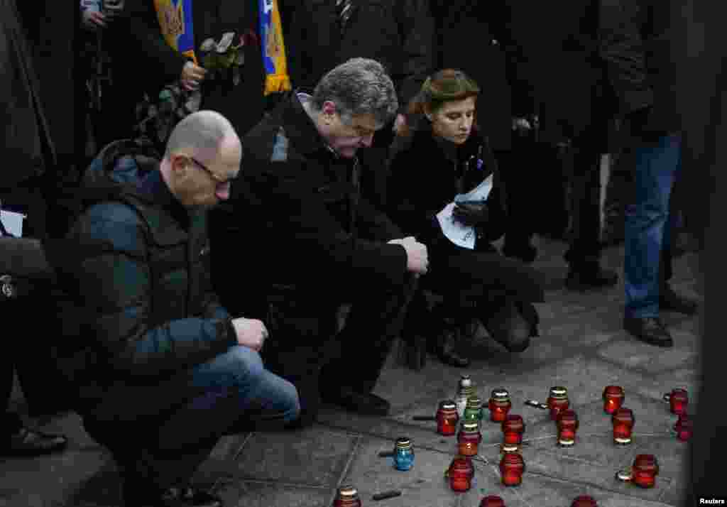 Ukraina Prezidenti Petro Poroshenko (markazda), uning rafiqasi va Bosh vazir Arseniy Yatsenyuk Kiyevda o'tgan tinchlik marshida sham yoqmoqda, 18-yanvar, 2014-yil.