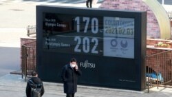 Olimpiada o'yinlarigacha qolgan vaqtni ko'rsatuvchi tablo qarshisida. Tokio, 3-fevral, 2021.