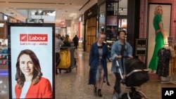Shoppers walk past an electronic billboard showing a photo of New Zealand Prime Minister Jacinda Ardern in Christchurch, New Zealand, Oct. 14, 2020.