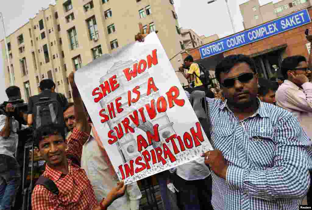 Demonstrators hold a sign outside a court where four men were sentence to death for a gang rape, New Delhi, Sept. 13, 2013.