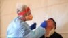 A health care worker tests a patient for COVID-19 at a testing facility in Kilmore outside of Melbourne, Australia, Oct. 6, 2020.