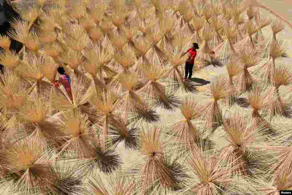 Employees from a bamboo industry company dry semi-finished bamboo chopsticks in a village in Xingan county, Jiangxi province, China.
