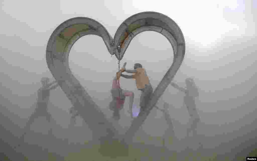 Burning Man participants perform a shibari rope scene during a desert dust storm inside the heart of the "Identity Awareness - Family" art project created by artist Shane Pitzer on the 2nd day of the annual Burning Man arts and music festival in the Black Rock Desert of Nevada, Aug. 29, 2017.