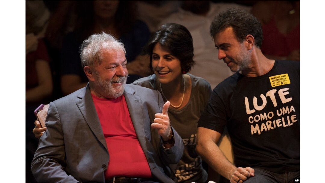 Brazil's former President Luiz Inacio Lula da Silva, left, talks to Manuela D'Avila of Brazil's Communist Party and Rio state Congressman Marcelo Freixo during his presidential campaign rally with members of his Workers Party and leaders of other left-win