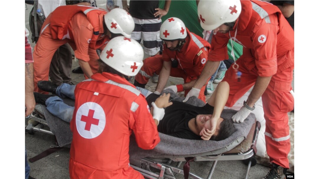 The Lebanese Red Cross take a hunger striker to a waiting ambulance. The tents of hunger strikers were attacked, with a number of the hunger strikers arrested earlier in the day, Sept. 16, 2015. (J. Owens/VOA)