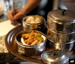 FILE - A server writes down what a customer bought from his food cart at Bo Lings Chinese restaurant in Kansas City, Mo. Chinese migration historian Young said few migrants can pay smugglers' fees up front; many work at restaurants to pay back debts.