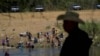 Migrants, many from Haiti, wade across the Rio Grande from Del Rio, Texas, to return to Ciudad Acuna, Sept. 22, 2021, some to avoid possible deportation from the U.S. and others to get supplies.