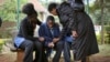 Stephen, center, who lost his father in Saturday's attack at the Westgate Mall in Nairobi, Kenya, is comforted by relatives as he waits for the post mortem exam at the city morgue, Sept. 23, 2013. 