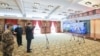 戴着口罩的中国国家主席习近平视察火神山医院时通过视频向新冠病毒感染者和医护人员招手。（2020年3月10日）
