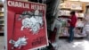 The front page of the new issue of satirical French weekly Charlie Hebdo entitled "C'est Reparti" ("Here we go again"), is displayed at a kiosk in Nice, Feb. 25, 2015. 