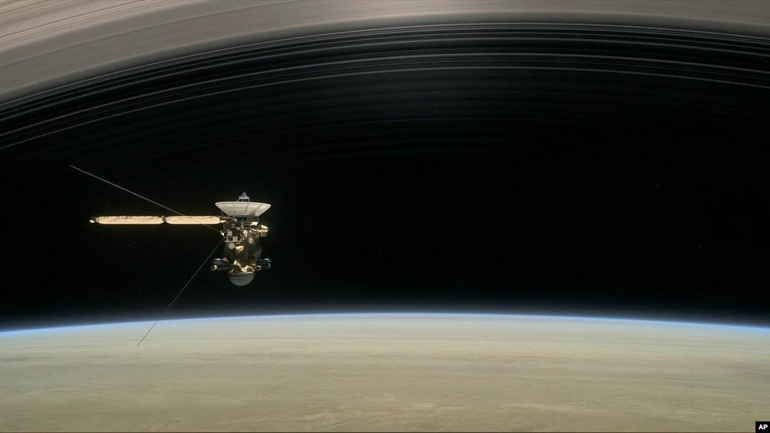 FILE - This image made available by NASA in April 2017 shows a still from the short film "Cassini's Grand Finale," with the spacecraft diving between Saturn and the planet's innermost ring. 