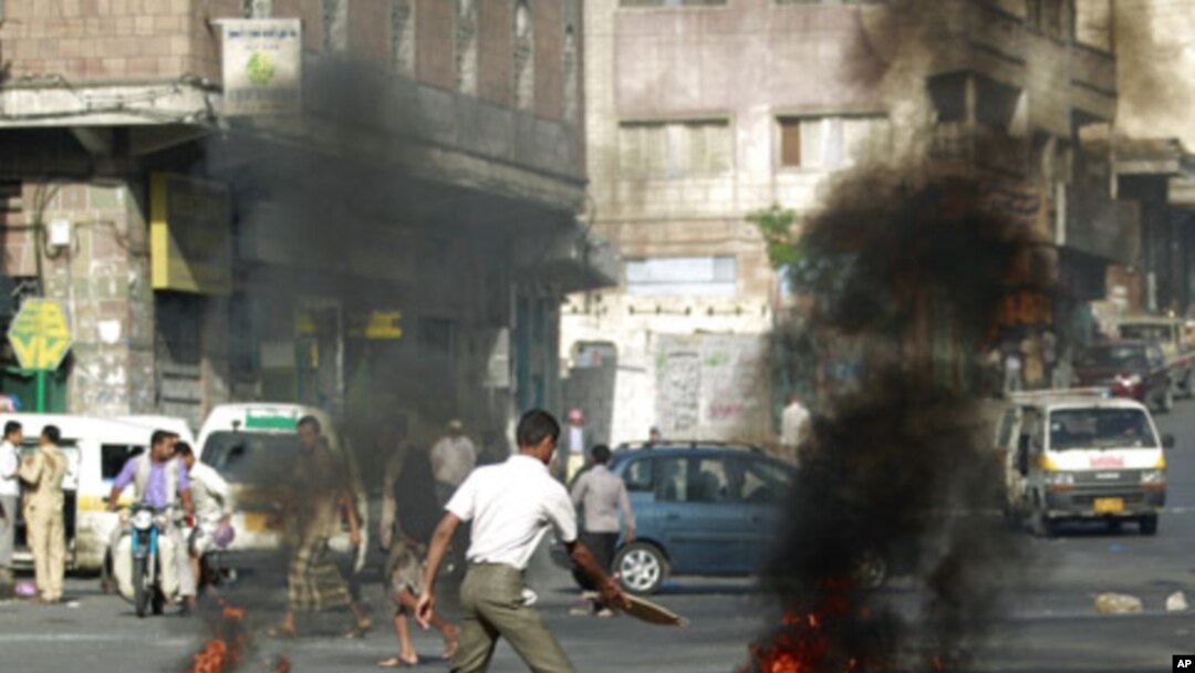 An anti-government protester burns tires during a protest to demand the ouster of Yemen's President Ali Abdullah Saleh in the southern city of Taiz, May 10, 2011