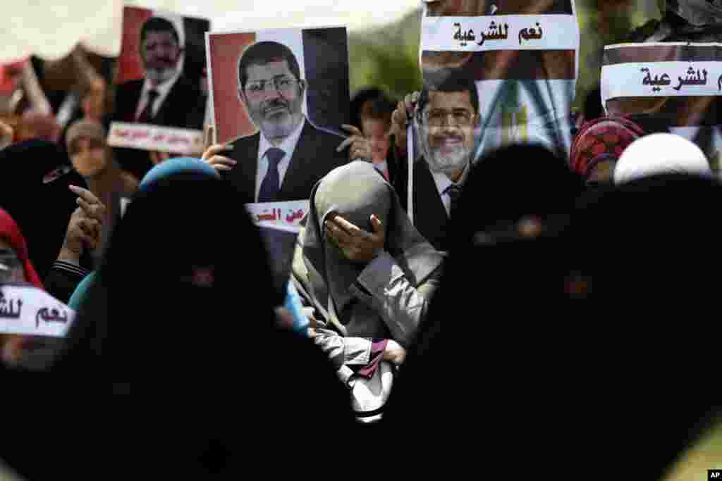 A supporter of ousted Egypt's President Mohamed Morsi cries during a protest near the University of Cairo, Giza, Egypt, Friday, July 5, 2013. Arabic reads, "Yes for the legitimacy." Egypt's Muslim Brotherhood called for a wave of protests Friday, furious over the military's ouster of its president and arrest of its revered leader and other top figures, raising fears of violence and retaliation from Islamic militants.