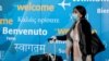 FILE - A traveler wears a face mask as she arrives at John F. Kennedy International Airport in New York City, March 20, 2020. 