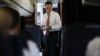 Republican presidential candidate, former Massachusetts Governor Mitt Romney, smiles as he speaks to advisers and staff members on his campaign plane in Denver, October 4, 2012.