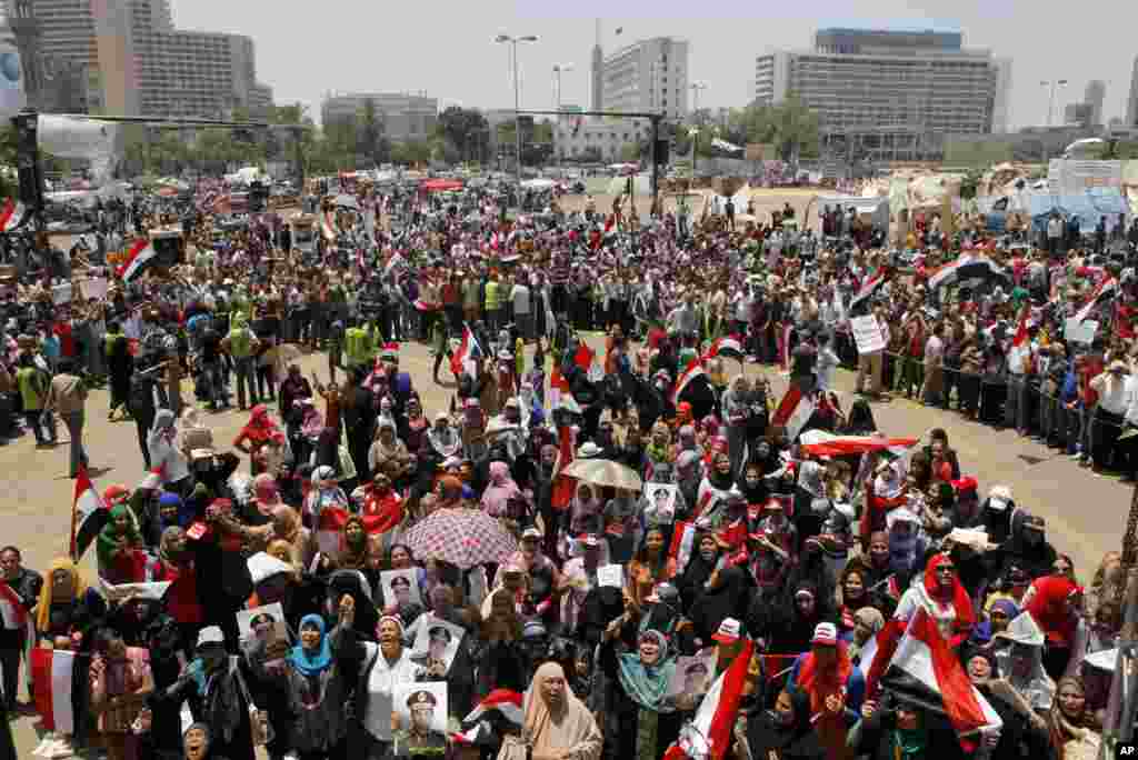 Opponents of Egypt's ousted president Mohamed Morsi wave national flags and posters showing Lt. Gen. Abdel-Fattah el-Sissi in Tahrir Square, in Cairo, Egypt, Friday, July 5, 2013. Egypt's Muslim Brotherhood called for a wave of protests Friday, furious o