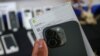 FILE - An Indonesian customs official shows a smuggled iPhone 16 Pro Max before destroying it after it was confiscated alongside dozens of Apple phones and tablets, at the customs office of Soekarno–Hatta International Airport in Tangerang, Banten, on November 29, 2024. 