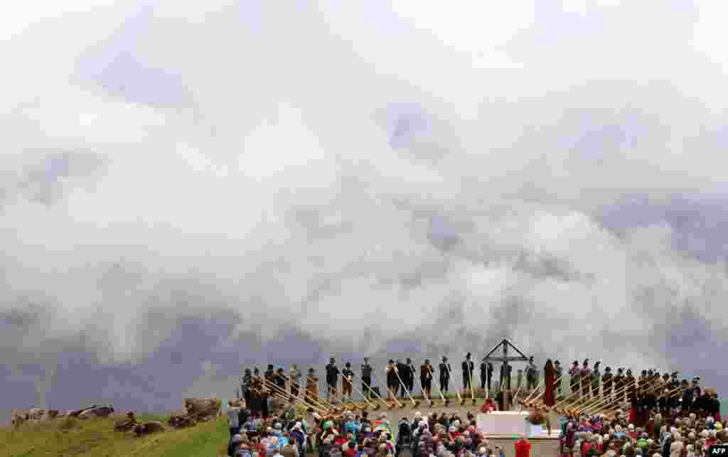 Alphorn blowers play their instruments during the so-called "Berglar Kirbe" outdoor church service dedicated to Saint Jakobus on the Fellhorn mountain in Oberstdorf, southern Germany.