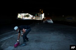 Thurman Butler Jr., 66, who is homeless, sweeps around his tent, Dec. 1, 2017, in Los Angeles. "A lot of people in America don't realize they might be two checks, three checks, four checks away from being homeless," said Butler who became homeless after he was evicted from his apartment.
