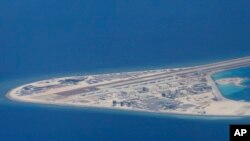 菲律宾空军一架运输机在南中国海南沙群岛的中国制造的人造岛礁渚碧礁上空飞越时拍摄的照片，显示人造岛礁上的简易机场和建筑物。（2017年4月21日）