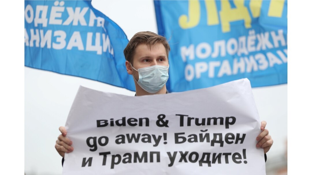 FILE - An activist of the Liberal Democratic Party of Russia holds a placard during a demonstration ahead of the U.S. presidential election, in front of the U.S. embassy in Moscow, Russia, Oct. 31, 2020.
