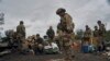 Фото: український військовий соїть на російському прапорі в Ізюмі, 13 вересня 2022 року.(AP Photo/Kostiantyn Liberov)