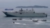 FILE - the Royal Australian Navy HMAS Adelaide cruises alongside landing crafts with Philippine Marines and Australian troops as they conduct a joint Humanitarian Aid and Disaster Relief (HADR) exercise off Subic Bay in northwestern Philippines.