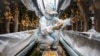 FILE - A worker wearing a protective suit harvests potato tubers at a greenhouse in Yakeshi, Inner Mongolia, China, June 16, 2024. 