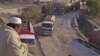 A driver sits overlooking trucks parked along the road, including those carrying supplies to NATO forces in Afghanistan, near Pakistan's Torkham border, after it was shut down on November 26, 2011. 