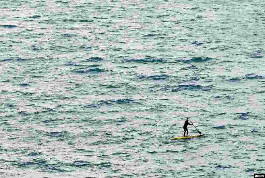 A man uses a stand up paddle (SUP) board during a windy day on Lake Leman in Cully, Switzerland.